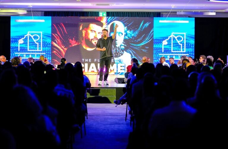 Speaker presenting on stage to a conference audience